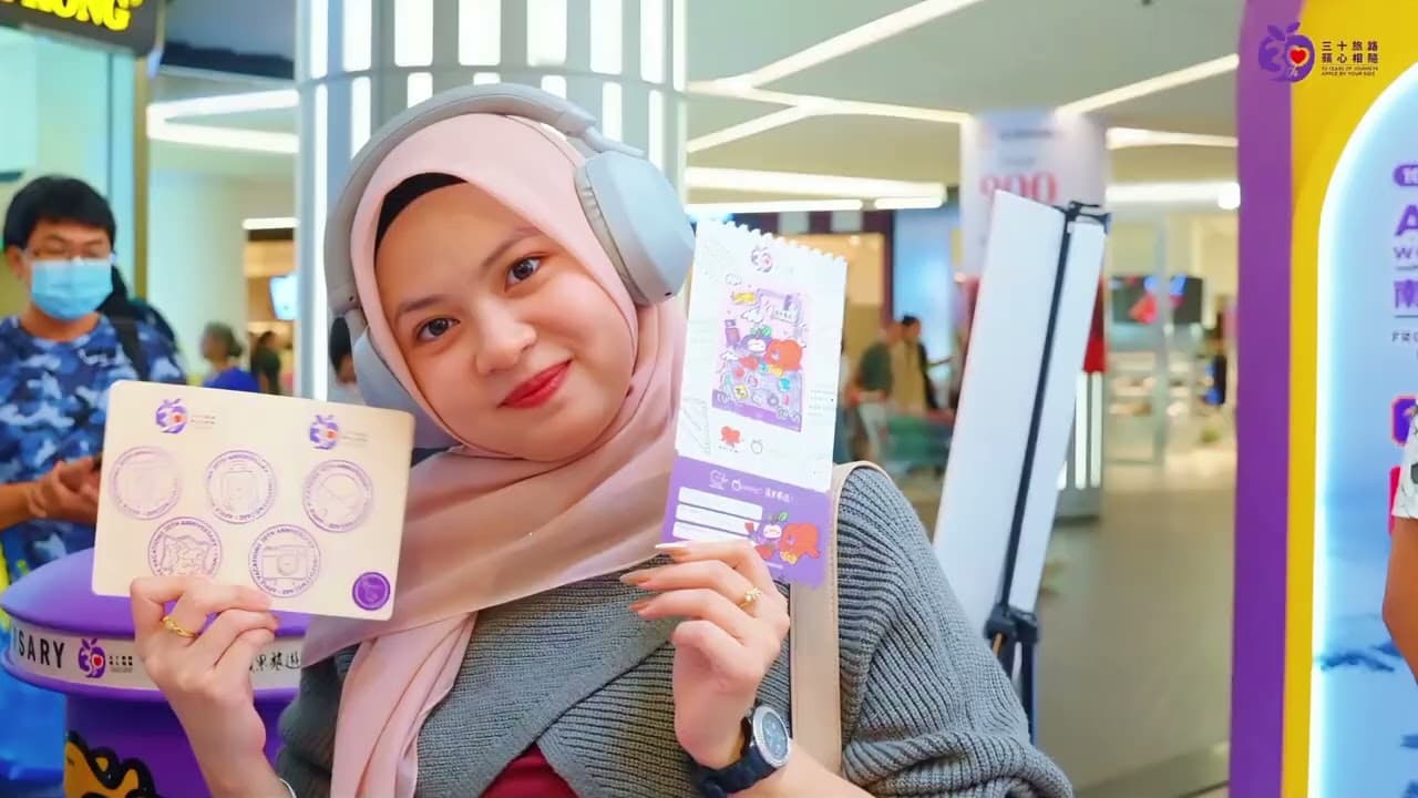 A guest holds up a promotional card at a mall activation